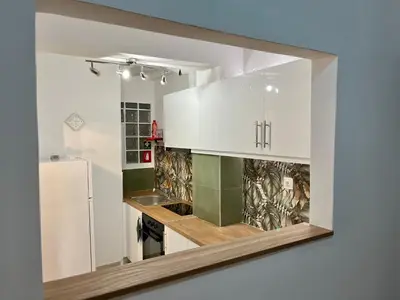 a kitchen with white cabinets and a refrigerator at New City Apartment Neos Kosmos in Athens