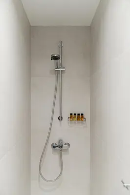 a shower in a bathroom with a shower head at Athens Sea Front Apartment, Varkiza in Varkiza