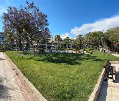 a park with a bench and trees and buildings at Athens Sea Front Apartment, Varkiza in Varkiza