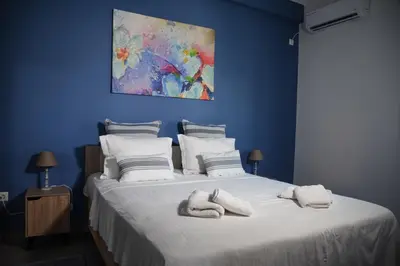 a blue bedroom with a bed with towels on it at Velvet new apt in Ilissia in Athens