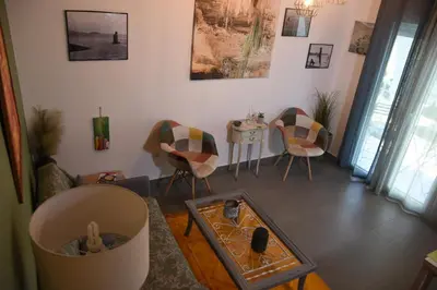 a living room with a table and chairs at Velvet new apt in Ilissia in Athens