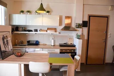 a small kitchen with a wooden table in a room at Velvet new apt in Ilissia in Athens