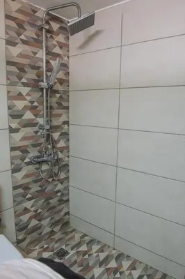a shower in a bathroom with a wall at Urban Oasis, Stylish Short Stay Apartment in Piraeus Center in Piraeus