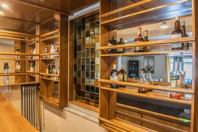 a bar with many bottles of alcohol on shelves at Urban Oasis, Stylish Short Stay Apartment in Piraeus Center in Piraeus