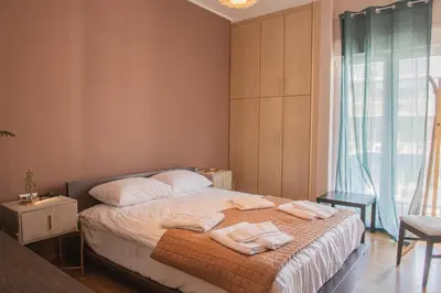 a bedroom with a bed with two towels on it at Urban Oasis, Stylish Short Stay Apartment in Piraeus Center in Piraeus