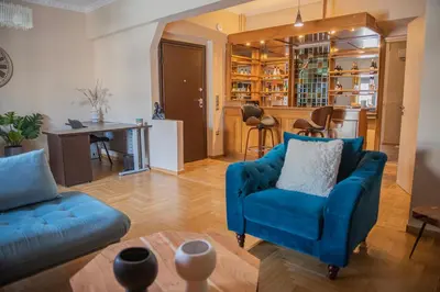 a living room with a blue couch and a table at Urban Oasis, Stylish Short Stay Apartment in Piraeus Center in Piraeus