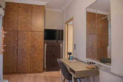a room with wooden cabinets and a table with chairs at Urban Oasis, Stylish Short Stay Apartment in Piraeus Center in Piraeus