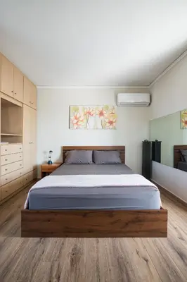 a bedroom with a large bed and wooden floors at Loft condo next to metro station. Amazing view! in Athens