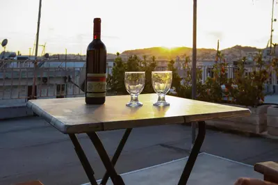 a bottle of wine and two glasses on a table at Loft condo next to metro station. Amazing view! in Athens