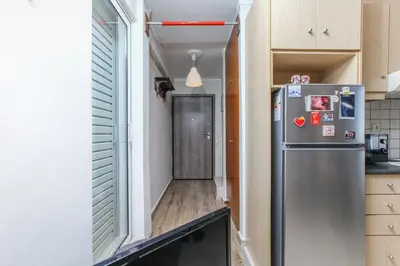 a small kitchen with a refrigerator and a hallway at Loft condo next to metro station. Amazing view! in Athens