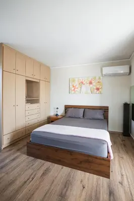 a bedroom with a large bed and wooden floors at Loft condo next to metro station. Amazing view! in Athens