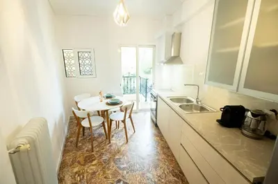 a kitchen with a table and chairs and a sink at Love Travel Athens Apartments in Athens