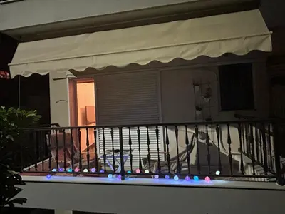 a balcony with an awning and lights on it at Love Travel Athens Apartments in Athens