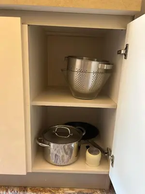 a cupboard with a bowl and a pot in it at Love Travel Athens Apartments in Athens