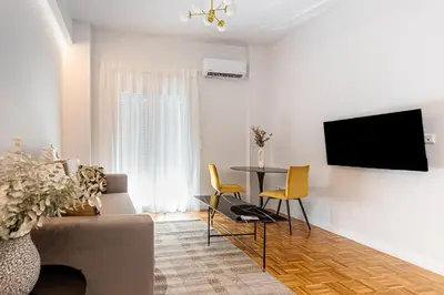a living room with a couch and a table with chairs at Phaedrus Living: Luxury Flat Panormou in Athens