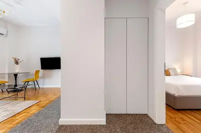 a bedroom with white walls and a bed and a table at Phaedrus Living: Luxury Flat Panormou in Athens