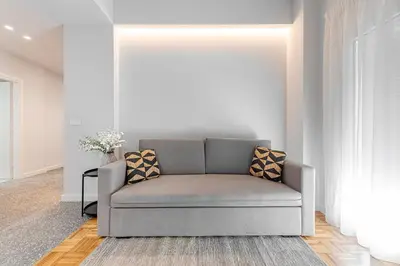 a gray couch in a living room with a window at Phaedrus Living: Luxury Flat Panormou in Athens