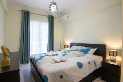 a bedroom with a large bed with blue pillows at Luxury quiet apartment near Metro in Athens