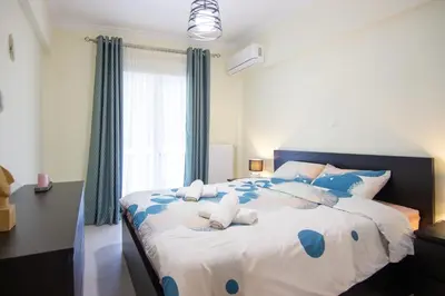 a bedroom with a large bed with blue pillows at Luxury quiet apartment near Metro in Athens