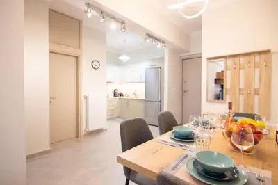 a kitchen and dining room with a wooden table and chairs at Luxury quiet apartment near Metro in Athens