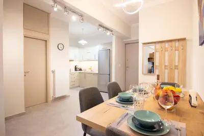 a kitchen and dining room with a wooden table and chairs at Luxury quiet apartment near Metro in Athens