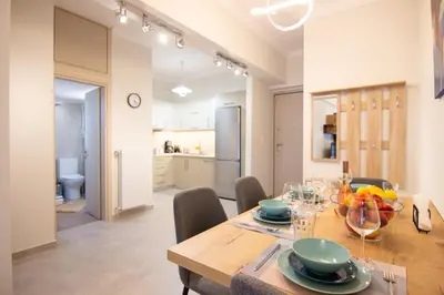 a kitchen and dining room with a table and chairs at Luxury quiet apartment near Metro in Athens