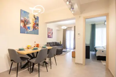 a dining room and living room with a table and chairs at Luxury quiet apartment near Metro in Athens