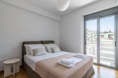 a white bedroom with a large bed with towels on it at Light in Athens