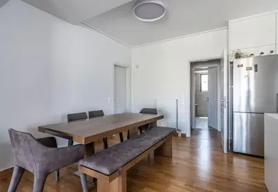 a dining room with a table and chairs and a refrigerator at Light in Athens