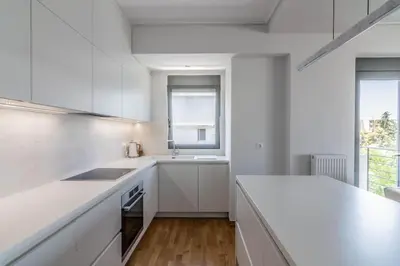 a white kitchen with a counter and a sink at Light in Athens