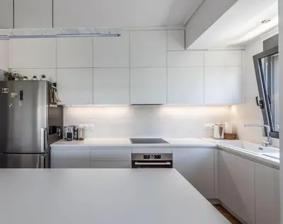 a kitchen with white cabinets and a stainless steel refrigerator at Light in Athens