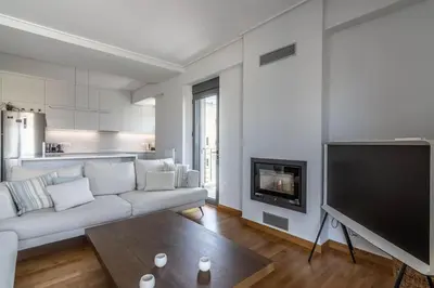 a living room with a white couch and a flat screen tv at Light in Athens