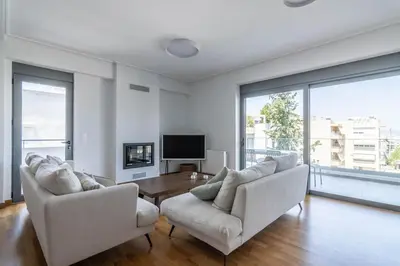 a living room with two white chairs and a table at Light in Athens