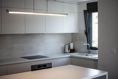 a kitchen with white cabinets and a sink at Light in Athens