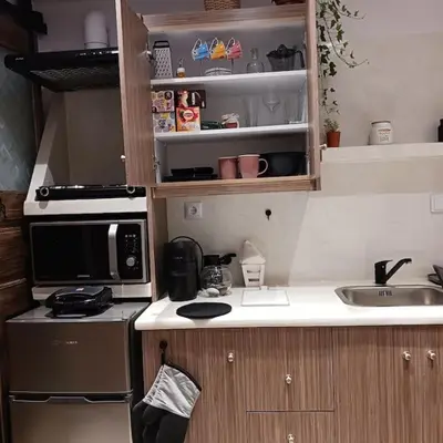 a small kitchen with a microwave and a sink at Boutique Eptalofos 15min from airport and sea in Kouvarás
