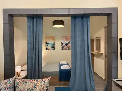a bedroom with a bed with blue curtains in it at Spacious and beautiful house in Piraeus