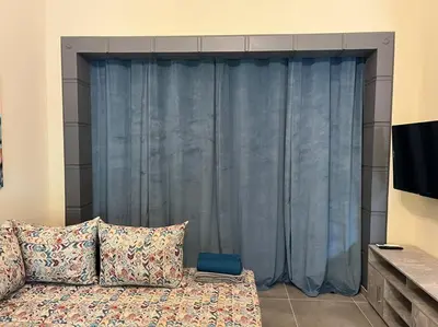 a couch in a living room with a blue curtain at Spacious and beautiful house in Piraeus