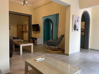 a living room with a chair and a table at Spacious and beautiful house in Piraeus