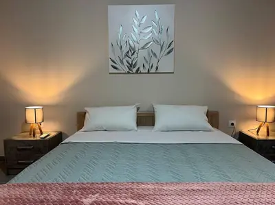 a bedroom with a large bed with two lamps on tables at Spacious and beautiful house in Piraeus