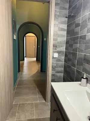 a hallway of a bathroom with a sink and a mirror at Spacious and beautiful house in Piraeus