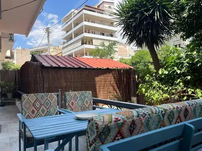 a blue table and chairs on a patio with a building at Spacious and beautiful house in Piraeus