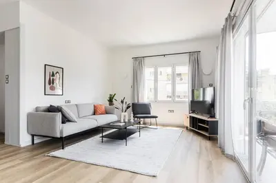 a white living room with a couch and a tv at Breezy 2BR Apartment by Marina Flisvos by UPSTREET in Athens