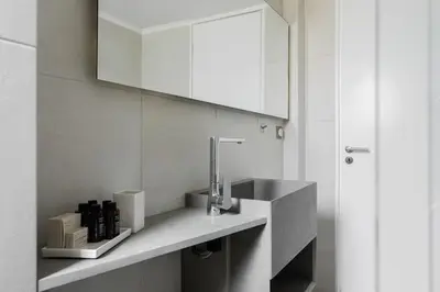 a bathroom with a sink and a mirror at Breezy 2BR Apartment by Marina Flisvos by UPSTREET in Athens
