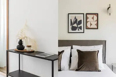 a bedroom with a bed and a table with a laptop at Breezy 2BR Apartment by Marina Flisvos by UPSTREET in Athens
