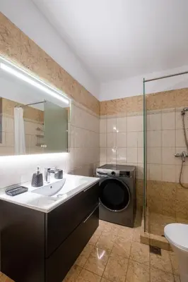 a bathroom with a sink and a washing machine at Casa Del G in Metókhi