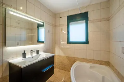 a bathroom with a sink and a tub and a mirror at Casa Del G in Metókhi