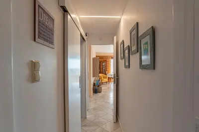 a hallway with pictures on the walls of a house at Feliz Apt- Breathtaking Seaview and Sunset by ΜΡS in Anavissos