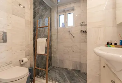 a bathroom with a shower and a toilet and a sink at Feliz Apt- Breathtaking Seaview and Sunset by ΜΡS in Anavissos