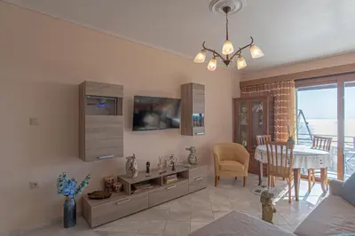a living room with a couch and a dining room at Feliz Apt- Breathtaking Seaview and Sunset by ΜΡS in Anavissos
