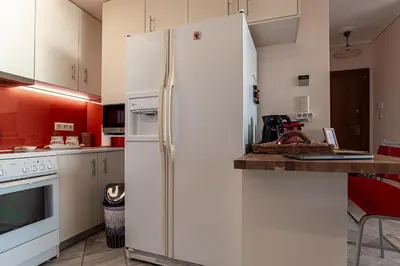 a kitchen with a white refrigerator and a counter at Feliz Apt- Breathtaking Seaview and Sunset by ΜΡS in Anavissos